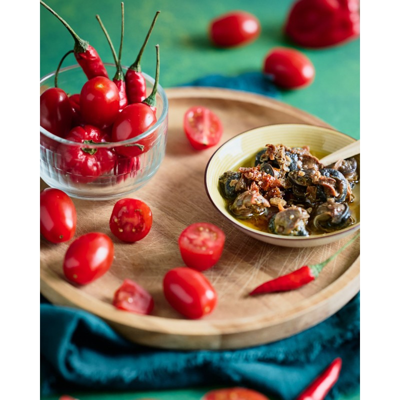 Tapas d'escargots à picorer huile d'olive, tomates séchées et piment